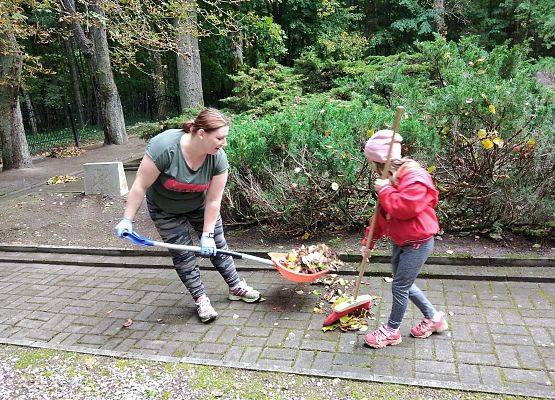 uczennica naszej szkoły wraz z mamą zgrabia liście na cmentarzu w Krępie Kaszubskiej