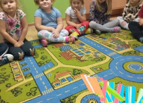 Młodsza grupa - wspólnie wykonujemy łańcuch na choinkę