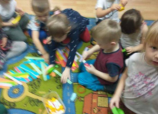 Młodsza grupa - wspólnie wykonujemy łańcuch na choinkę