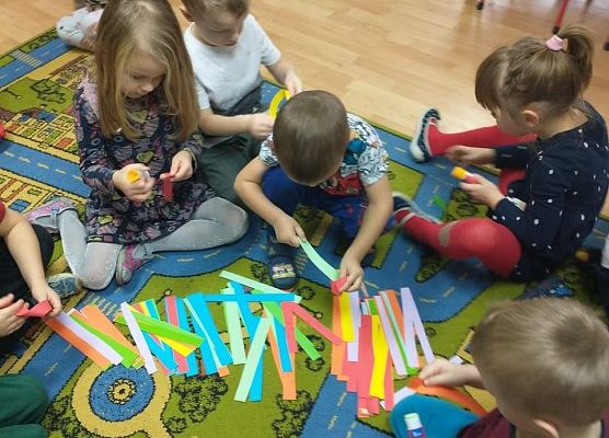 Młodsza grupa - wspólnie wykonujemy łańcuch na choinkę