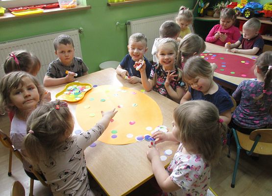 Młodsza grupa dekoruje pisankę