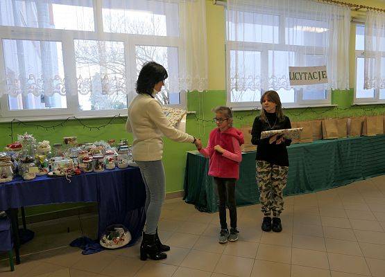 dwie uczennice otrzymują nagrody