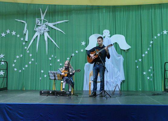 Pan Mikołaj i uczennica drugiej klasy Melania wykonują dwie kolędy Cicha Noc i Dzisiaj w Betlejem