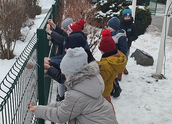 Uczniowie dokarmiają ptaki